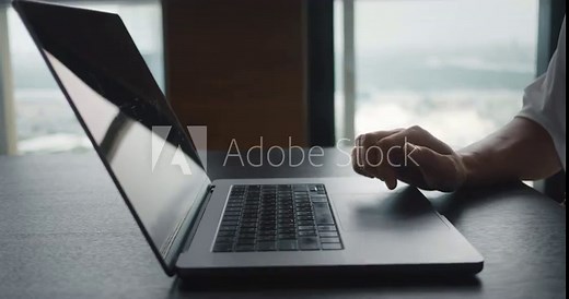 Successful businessman sitting at desk working at laptop in office. Business person using touch pad laptop computer in front of window at office Stock Video