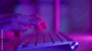 Male hands are typing on the keyboard, typing text and press enter. Slow motion footage with smooth motion. Neon light. High quality 4k footage