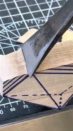carving wooden block using sharp metal chisel and making pattern on wood material on black mat area