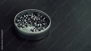 Air gun bullets on a fabric dark background in a box. Falling bullets from an air rifle or pistol