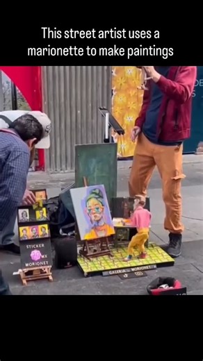 Concierge of Art | Art Collector on Instagram: "This street artist doesn’t hold the brush at all. Instead, they paint by controlling a marionette 🎭🎨 The puppet’s hands are attached to strings that guide the brush across the canvas, turning each artwork into a live performance. By adjusting tension and movement, the artist controls pressure, direction, and flow, blending puppetry with painting in real time. It’s art, theater, and technique all happening at once — a reminder that creativity isn’