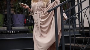 Elegant woman with flying skirt at stairs.