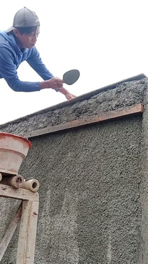 plastering the fortress walls using a cement trowel.