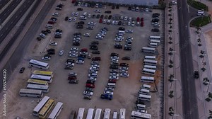 Big parking lot in downtown crowded by many cars and buses timelapse aerial view. Vehicles moves in and out