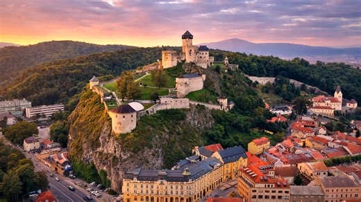An ancient castle standing high above a modern city