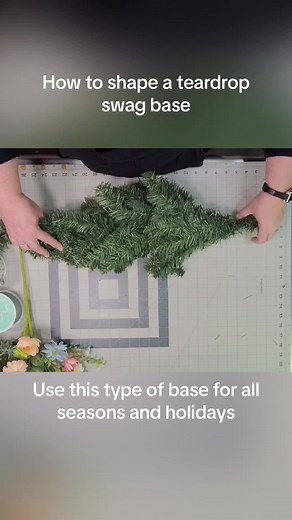 How to shape a teardrop swag wreath base our of the shipping box. Swag wreaths are vertical wreaths and used for all seasons and holidays. #swagwreath #swagwreathclass #silkflowers #wreathmaking #wreaths #wrrathsfordoor #howtomakewreaths