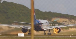 Plane's engine erupts in flames with more than 300 people onboard as tyres explode on takeoff