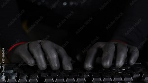 Masked Character Hacker Typing on a computer keyboard wearing gloves