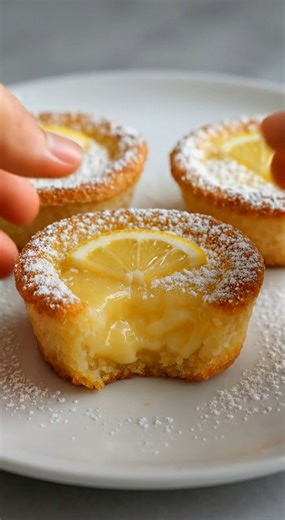 🍋 Bakery-Style Baby Lemon Custard Cakes | Soft, Creamy, and Perfectly Tart There is something so nostalgic about the way a warm lemon dessert makes the whole house smell like sunshine. These baby lemon custard cakes are a dream come true, with a soft, buttery base and a thick, gooey center that melts in your mouth with every single bite. Yield: 6 large muffin cakes Ingredients: 3/4 cup whole milk 3 large eggs, room temperature 1/2 cup granulated sugar 1/3 cup all-purpose flour 2 tablespoons cor