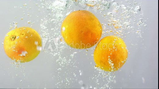 Orange and water splash. Integration of oranges with water. Artistic footage of oranges falling into water in slow motion.