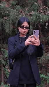 Searching for a network, a frustrated woman holds her mobile phone high, battling the lack of service deep in nature.