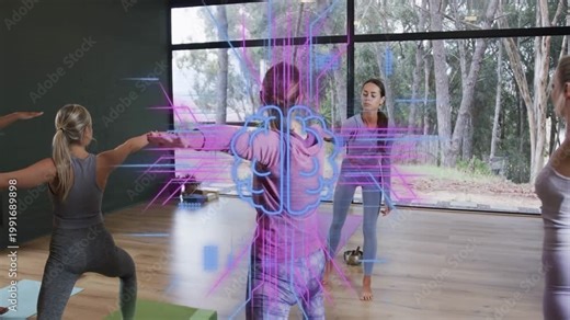 Central yogi holding warrior pose in yoga studio teacher cueing holo code overlay showing alignment