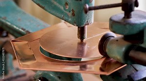 The master, using a copper sheet cutting machine, cuts a circle into the product