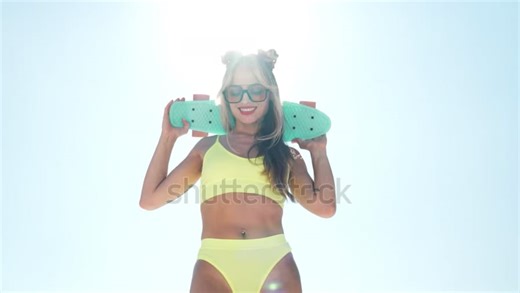 stock-footage-young-beautiful-smiling-blond-woman-posing-in-the-street-in-sunny-day-sexy-model-in-swimwear