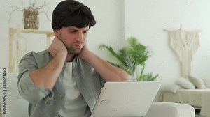 Young man receiving very bad news on her laptop computer screen, upset and frustrated with failure