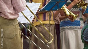 Street Trombonist playing a trombone in the street on city feast . Sheet of music on background , 4K 3840 x 2160 ultra high definition footage