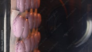 homemade macaron cookies. Time lapse video of purple macarons are baked in the oven. Close-up macaron grow. vertical video