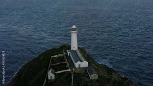 South Stack lighthouse aerial view circling rugged island nautical landmark during sunrise