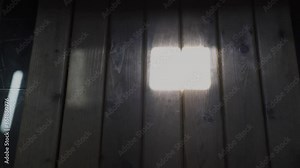 Light coming through a small window passes over the wooden floor.