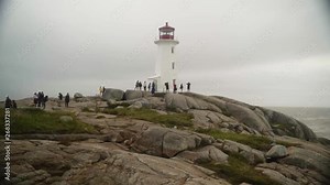 Shot moving sideways showing a lighthouse during a foggy day - beautiful moddy footage at the coast of Nova Scotia, Canada