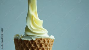 A close-up of soft ice cream being poured into a waffle cone, symbolizing sweetness, summer, and a refreshing treat.