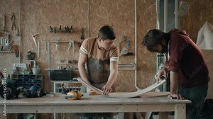 Furniture maker measures the wooden lath using tape measure and calipers. two man hands in work discuss process. The concept of using experience for accurate work.