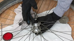 A man disassembles the hub of the rear wheel of a bicycle. Do-it-yourself mountain bike repair at home. Close-up