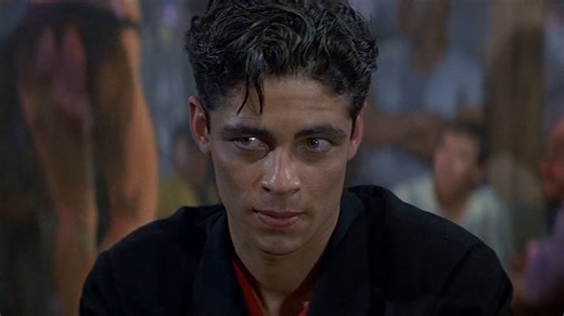 Bond (Timothy Dalton) and Pam Bouvier (Carey Lowell) square up to Sanchez’s men led by Dario (Benicio Del Toro) in the Barrelhead bar in LICENCE TO KILL. “I portrayed Pam as gritty and tough,” said Lowell. “When Bond meets her at the bar, she’s wearing a black leather vest and carrying a sawn-off shotgun. She’s flinging men over her shoulder and smashing bottles on their heads.” | James Bond 007