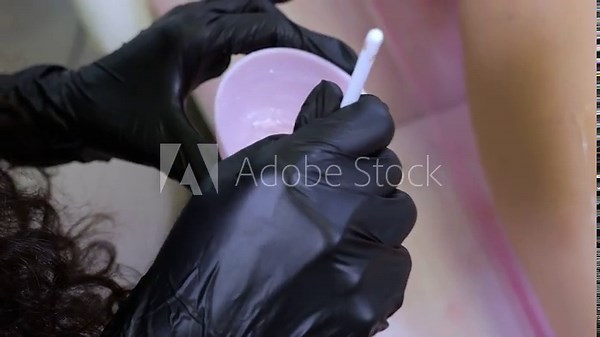 Close-up of the depilation master mixing the gel for application to the skin, laser depilation procedure. The cosmetologist is preparing to work with the client.