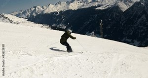Alpine skiing in beautiful mountain landscape in tyrol. Panorama skiing with big mountains on a steep ski slope. Slomotion skiing 4k video male skier with good ski technique in short ski turns.