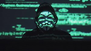 Anonymous in the mask steals user data on the network. hacker against the background of running code