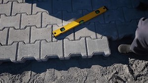 Worker Installing Paving Slabs with Hammer