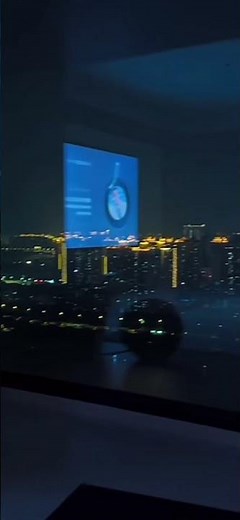 Night Cityscape View Through Window with Digital Screen