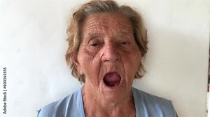 Elderly woman showing her mouth without teeth and with prosthetic screws and implant