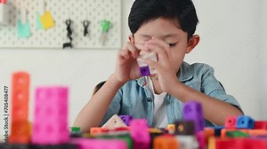 Asian Young Child Playing Colorful Plastic Cubes on Desk at Home. Learning and Education on Counting Cube in Math, Develop the Brain and Meditation while Playing. Stock Video