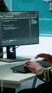 Vertical Video IT expert monitors AI brain intelligence system to collect crucial real time data for a new defense military operation on pc in command post. Security protocols for an intense mission