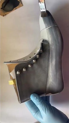 painting grey color on white leather boot manually using brush