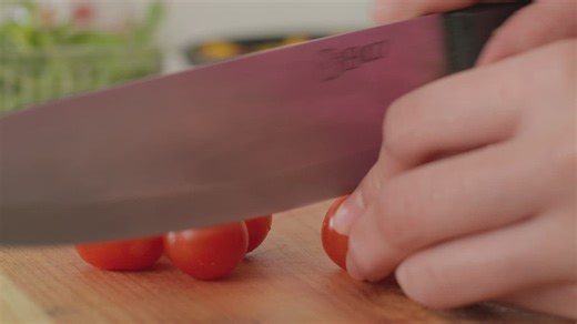 Splitting cherry tomatoes for a salad - Free Stock Video