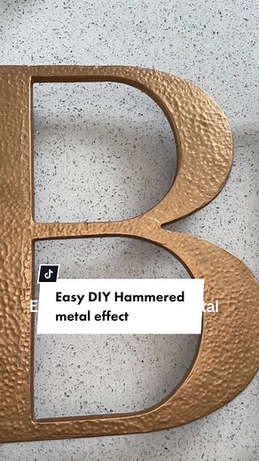Easy DIY hammered metal effect can be achieved with these simple supplies: ✨Joint compound ✨a Marble ✨Black matte spray paint ✨Rub n buff color of choice. I applied a generous amount of joint compound and let it dry till it wasn’t sticky. I then used a marble to make the indentations. If you make a mistake just tap the compound with your finger and it’ll smooth over. Then once dry I sanded the edges and painted it matte black. Then I brushed on rub n buff in antique gold. Gorgeous hammered metal
