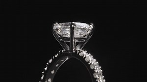 Premium stock video - Close up, diamond ring slowly rotating against black studio background