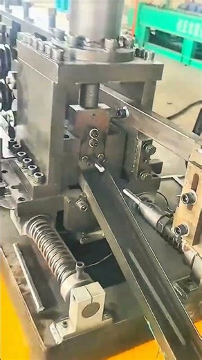 Rollers shape steel tube—springs and rails guide rhythm of industrial force and precision flow.