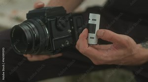 Setting up a film camera with a roll of film in hand to capture stunning moments creatively