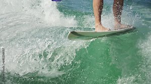 The man performs a trick - an ollie. Wakesurfing tricks. Close-up of the feet and wakesurf. Stock Video