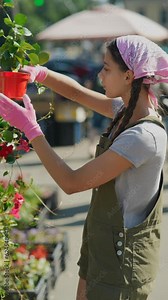 Young woman farmer at the farmers plants market, preparing to sell the product