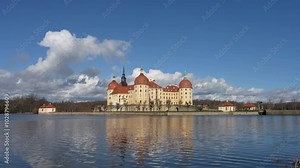 Beautiful famous Moritzburg Castle, castle above lake. Big clouds in sky. Castle is reflected in water. German architecture, Germany