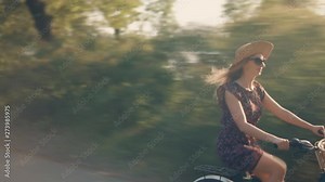 Cyclist Woman Cycling On Bicycle.Girl Cycling On Bike.Cyclist Beautiful Woman Wearing Dress Rides Bicycle.Happy Woman In Hat Riding On Bicycle.Pretty Girl On Bicycle.Woman With Blonde Hair Cycling
