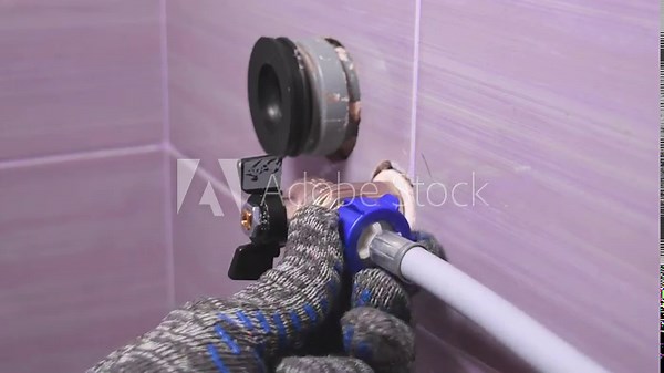 Plumber installs the hose from the washing machine. Connecting the washing machine or dishwasher to the water supply.