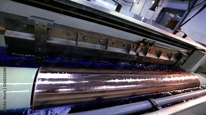 Printed shaft. Cylindrical press for wallpaper printing. The mechanism of printing on wallpaper. Modern printing press for wallpaper