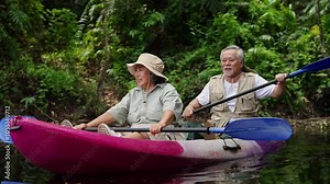 Happy Asian family senior couple kayaking in the river on summer holiday vacation. Healthy elderly people enjoy and fun outdoor active lifestyle travel nature, sport and rowing a boat in the lake.