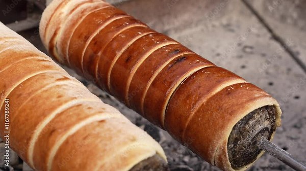 Traditional Hungarian Kürtös Kalács Sweet Spit Cake Roasting on Open Fire in a Rustic Setting